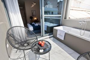 ein Badezimmer mit einem Tisch, Stühlen und einer Badewanne in der Unterkunft Trendy Hotel by Athens Prime Hotels in Athen