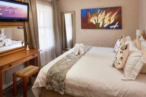 a bedroom with a bed with a teddy bear on it at First Group Hastings Hall in Cape Town