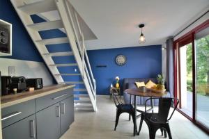 a kitchen with blue walls and a table with chairs at Domaine de Monplaisir82 in Montech