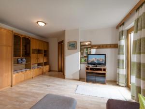 een woonkamer met een televisie en een bank bij Haus am Waldesrand in Ellmau +8 foto's
