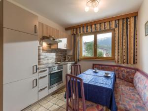 a kitchen and dining room with a table and a window at Haus am Waldesrand in Ellmau