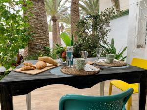 un tavolo con pane e bicchieri da vino sopra di La Casita de Galaila a Costa Calma