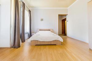 1 dormitorio blanco con 1 cama y suelo de madera en Best Apartment in the city centre, en Odessa