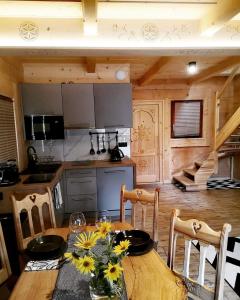 a kitchen with a wooden table with flowers on it at Chaty Misiagi in Poronin
