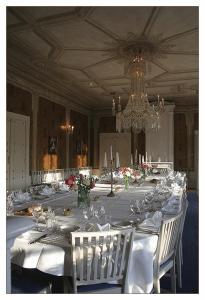 une grande grande table avec des tables et des chaises blanches dans l'établissement Bäckaskog Slott, à Fjälkinge