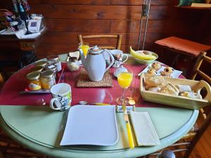 uma mesa com pequeno-almoço de pão e sumo de laranja em GREEN BIKE PYRENEES em Louvie Juzon