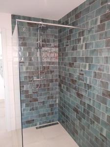 y baño con ducha de azulejos azules. en Maestro Concepcion Guidet, en Fuengirola