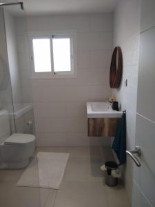 Baño blanco con aseo y lavamanos en Maestro Concepcion Guidet, en Fuengirola
