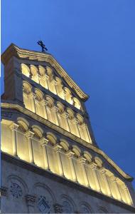 Un edificio con una torre con un orologio sopra di Al Duomo di Cagliari a Cagliari