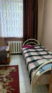 1 dormitorio con cama, ventana y alfombra en Hotel Uyut, en Kremenchuk