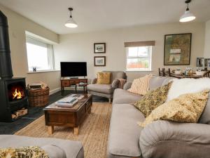 a living room with a couch and a fireplace at Waterside in Ravenglass
