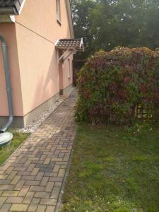a brick walkway next to a house with a bush at Dori's Fewo in Mittenwalde