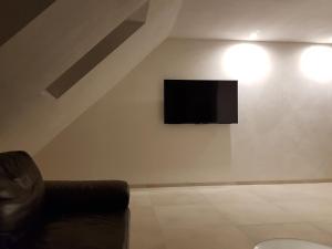 a living room with a couch and a television on a wall at Haus Soestblick - Ferienwohnung in Möhnesee