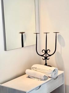 a bathroom with two towels on a shelf with a mirror at Xenias Rooms Apartments in Koroni