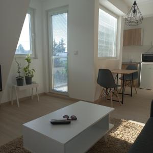 Il comprend un salon avec une table blanche et une cuisine. dans l'établissement Studio close to town centar, à Skopje