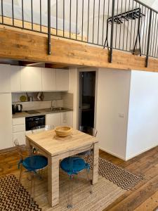 a kitchen with a wooden table and blue chairs at Il cortile in centro in Pesaro +18 photos