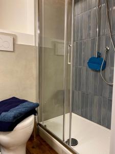 e bagno con doccia, servizi igienici e asciugamano blu. di Il cortile in centro a Pesaro