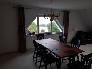 a dining room with a table and a large window at Haus Soestblick - Ferienwohnung in Möhnesee