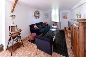 a living room with a blue couch and a table at Le Logis K, le charme au cœur de Saint Pair in Saint-Pair-sur-Mer