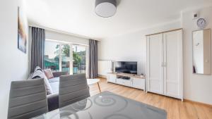 緬滋波爵的住宿－Apartamenty Sun & Snow Na Wydmach，带沙发和电视的白色客厅