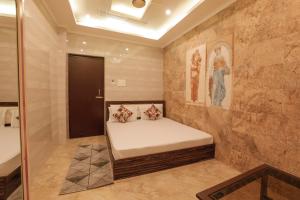 a small room with a bed in the corner at Hotel Grand Galaxy in Rishīkesh