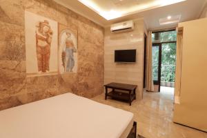 a room with a bed and a tv on a wall at Hotel Grand Galaxy in Rishīkesh