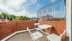 a patio with a table and chairs on a brick wall at Plac Neptuna, Sun & Snow in Międzyzdroje