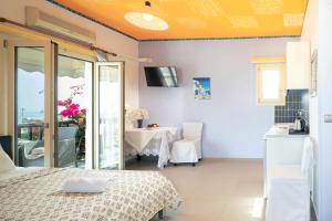 a room with a bed and a table and a balcony at KORIFI Adults Only in Hersonissos