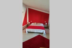 - une chambre rouge avec un lit avec un mur rouge dans l'établissement Honeycomb - casa vacanze, à Varèse