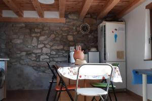 una mesa y sillas en una cocina con una pared de piedra en Las Estrellas de Laguarta, en Laguarta