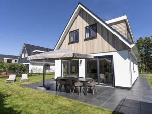 a house with a patio with a table and chairs at Attractive Holiday Home in De Koog Texel with Terrace in Westermient