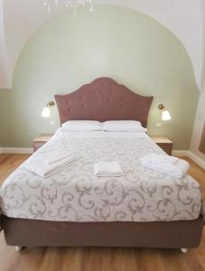 1 dormitorio con 1 cama grande y cabecero de madera en Opera Relais 85, en Messina