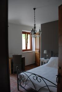 a bedroom with a bed and a chandelier at B&B Profumo delle Marche in Montefano