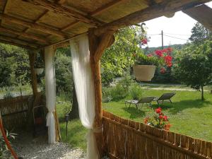 une terrasse couverte avec une clôture et un jardin fleuri dans l'établissement Őrségi Nomád-Lak Nomád 1, à Kercaszomor