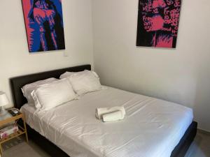 a bed with a white towel on top of it at Modern City Center Apartment Saripolou 2 in Limassol