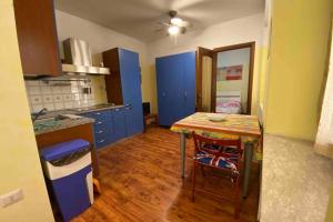 una cocina con armarios azules y una mesa con sillas en Un tocco provenzale a Savigliano, en Savigliano