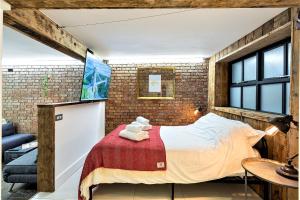 um quarto com uma cama e uma parede de tijolos em St Michaels Place em Bristol