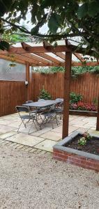 a table and chairs sitting under a wooden pergola at Beechwood in Bristol