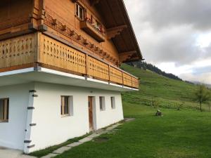 a building with a balcony on the side of it at Chalet bois soleil in Les Mosses