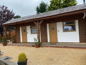 a small house with wooden doors and a patio at Beechwood in Bristol