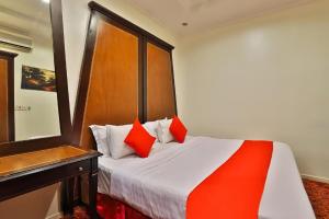 a bedroom with a bed with red pillows on it at قصر الحمراء للأجنحة الفندقية in Riyadh