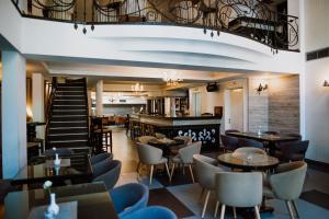 a restaurant with tables and chairs and a staircase at Bela Kuka Hotel in Bitola