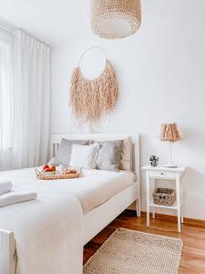 a white bedroom with a bed with a basket on it at Apartamenty Flat White Ruczajowa in Zielona Góra