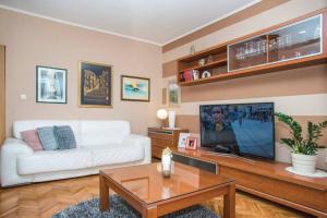 a living room with a white couch and a tv at VILLA NICOLE, Makarska - Poljica in Imotski