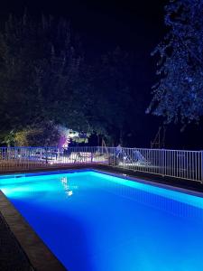 uma piscina azul à noite com uma cerca em Best Western Alexander Park Chambéry em Chambéry