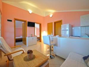 - une cuisine avec des murs orange et un comptoir dans l'établissement Apartments Mila, à Murter