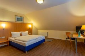 a hotel room with a bed and a desk at Best Western Waldhotel Eskeshof in Wuppertal