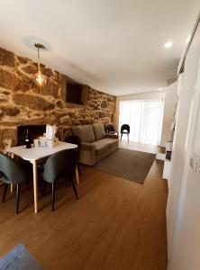 - un salon avec une table et un canapé dans l'établissement Casas de Penedones - Ventos da Cabreira, à Penedones