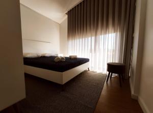 - une chambre avec un lit et une fenêtre avec 2 serviettes dans l'établissement Casas de Penedones - Ventos da Cabreira, à Penedones