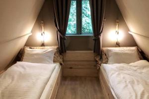 Duas camas num pequeno quarto com uma janela em Tipi d'Amis em Durbuy